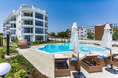a swimming pool with chairs and a building at Apartments in Complex Sunny Island Deluxe in Chernomorets