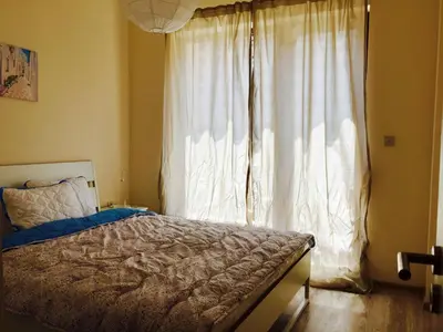 a bedroom with a bed and a large window at PSB Apartments in South Bay Varna in Varna City