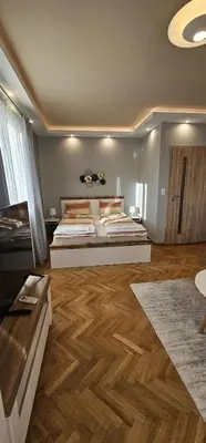 a bedroom with two beds and a wooden floor at Black Sea View - Luxory apartment by the sea in Burgas City