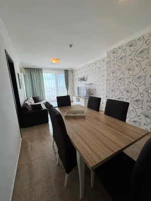 a dining room with a wooden table and chairs at OLYMP Apart-Complex in Sveti Vlas