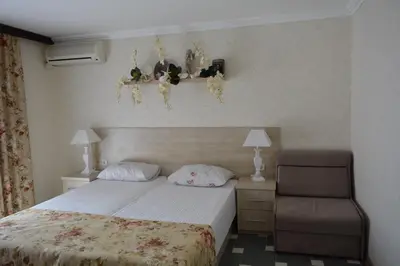 a bedroom with a bed and a chair at Hotel Morska Zvezda in Sozopol