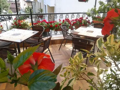 a patio with tables and chairs and flowers at Hotel Morska Zvezda in Sozopol