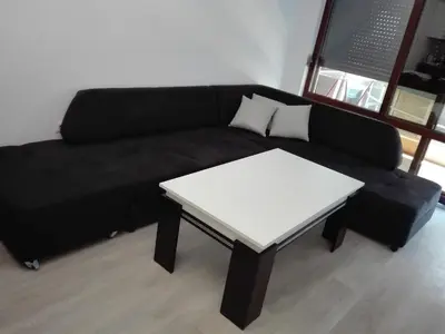 a black couch with a white table in a room at Апартамент Дарко in Pomorie