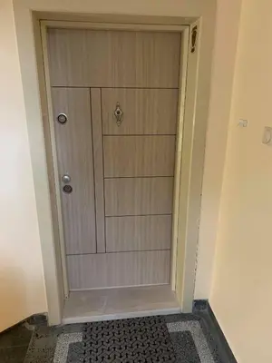 a wooden door in a hallway with a rug at De Luxe Studio Burgas, City Center in Burgas City