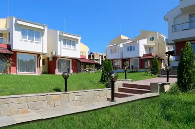 a row of houses on a green lawn with parking meters at St. Stefan Villas & Hotel in Sozopol