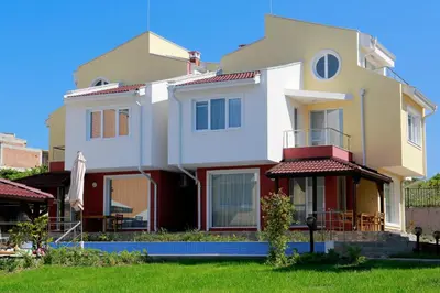 a large white house with a lawn in front of it at St. Stefan Villas & Hotel in Sozopol