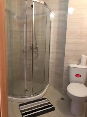 a bathroom with a shower with a toilet and a rug at Apartamenti Eli in Pomorie