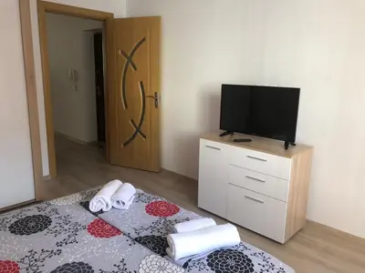 a bedroom with a bed with a television and towels at Apartamenti Eli in Pomorie
