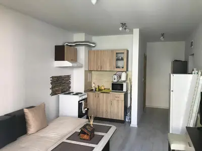 a living room with a couch and a kitchen at Apartamenti Eli in Pomorie