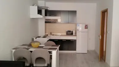 a kitchen with a table and chairs and a refrigerator at Apartamenti Eli in Pomorie