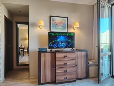 a living room with a tv on top of a dresser at Apartment in Hotel Royal Beach 5 Pool View in Sunny Beach