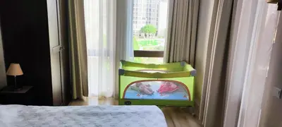 a bedroom with a childs chair in front of a window at Apartment in Hotel Royal Beach 5 Pool View in Sunny Beach