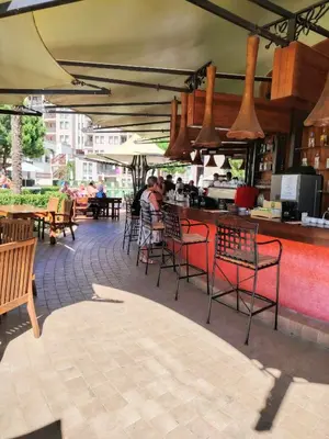 a patio with tables and chairs and a bar at Apartment in Hotel Royal Beach 5 Pool View in Sunny Beach
