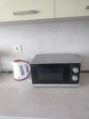 a microwave with a coffee mug next to a toaster at Jacky's House in Chernomorets