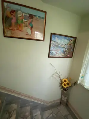 a room with two pictures on the wall and a vase of flowers at Jacky's House in Chernomorets