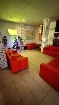 a lobby with red couches and a christmas tree at Sanny view South- Студия Мир авангарда in Sunny Beach
