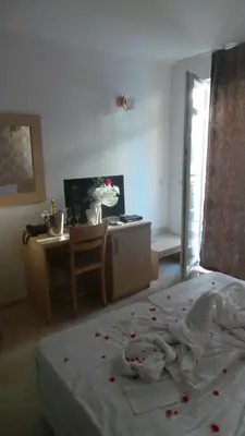 a bedroom with a bed with red flowers on it at Family Hotel Orios in Primorsko