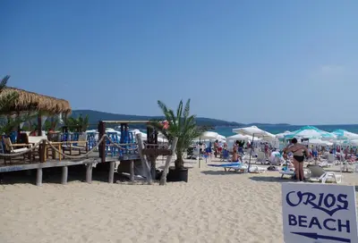 a crowd of people on a beach with a sign at Family Hotel Orios in Primorsko