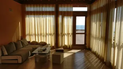 a living room with a couch and a large window at Club Priz in Primorsko