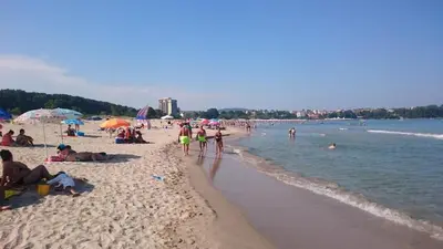 a group of people on a beach with the water at Club Priz in Primorsko