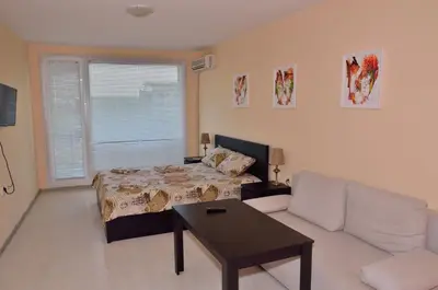 a living room with a couch and a bed at Club Priz in Primorsko