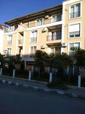 a yellow building with trees in front of it at Villa Gracia in Ravda
