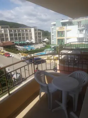 a balcony with a table and chairs and a view of a pool at Hotel Black Sea - Breakfast, Pool & Free Parking in Obzor
