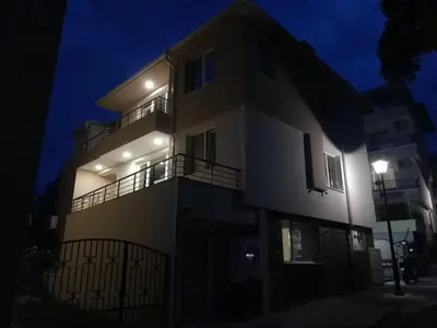 a building with lights on the side of it at night at Guest House Dimovi in Sozopol