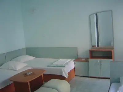 a small room with two beds and a mirror at Guest House Dimovi in Sozopol