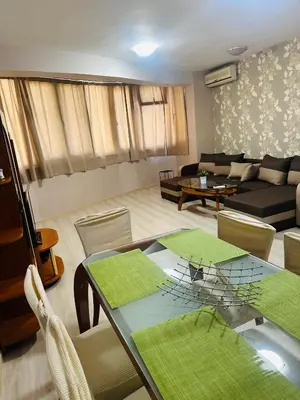 a living room with a table and a couch at Lux Apartment Sisi in Burgas City