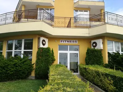 a yellow building with a fitness sign on it at AKB Apartment Sea View in Aheloy