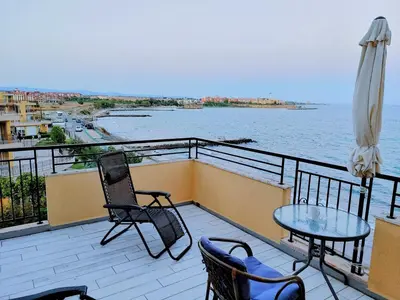a balcony with a table and chairs and the water at AKB Apartment Sea View in Aheloy