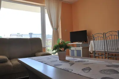 a living room with a couch and a table with a plant at Hotel BelleVille in Sunny Beach