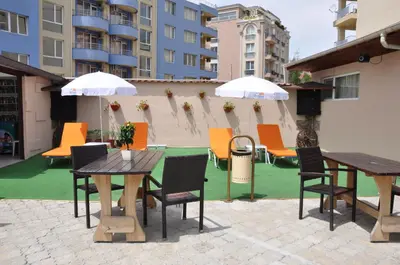 a patio with tables and chairs and umbrellas at Hotel BelleVille in Sunny Beach