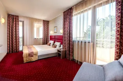 a hotel room with a bed and a large window at Hotel Capri in Nesebar