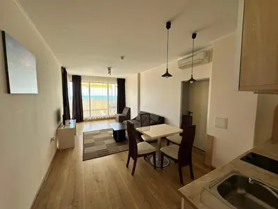 a kitchen and living room with a table and chairs at Hotel Capri in Nesebar