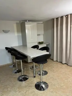 a kitchen with a table and black bar chairs at Villa Tunley in Razvalini Balchikioy