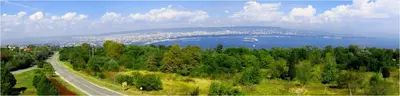 a road next to a lake with a city at Galata in Varna City