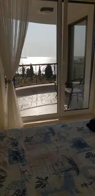 a bedroom with a view of the ocean from a balcony at Morning Star Deluxe in Chernomorets