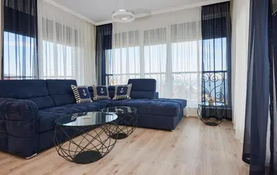 a living room with a blue couch and a table at Morning Star Deluxe in Chernomorets