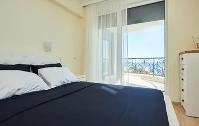a bedroom with a bed and a large window at Morning Star Deluxe in Chernomorets
