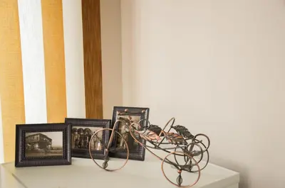 a table with framed pictures and a bike on it at Ivanovi Apartments in Burgas City