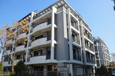 a white building with balconies on the side of it at Ivanovi Apartments in Burgas City
