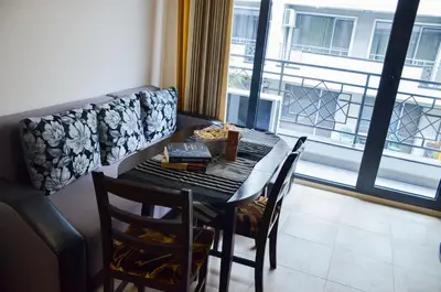 a dining table and chairs in a room with a window at Ivanovi Apartments in Burgas City