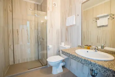 a bathroom with a toilet and a sink and a shower at Hotel Perla Beach Club - All Inclusive in Primorsko