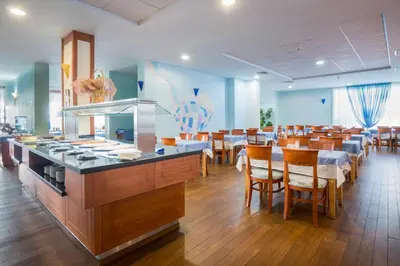 a restaurant with tables and chairs and a buffet at Hotel Perla Beach Club - All Inclusive in Primorsko
