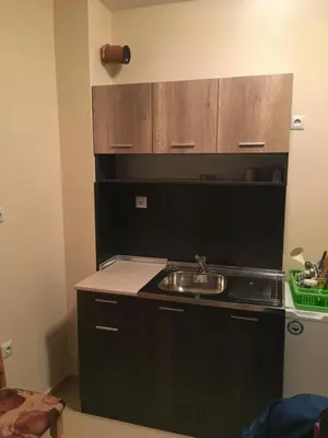 a kitchen with a sink and wooden cabinets at Apartment Martin Beach in Pomorie