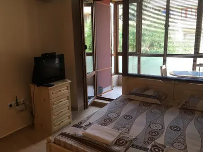 a bedroom with a bed and a tv and a window at Apartment Martin Beach in Pomorie