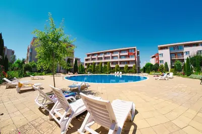 a patio with chairs and a pool in a building at Nessebar Fort Club Apartments in Sunny Beach