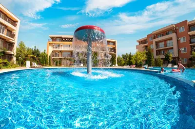 a pool with a fountain in the middle at Nessebar Fort Club Apartments in Sunny Beach